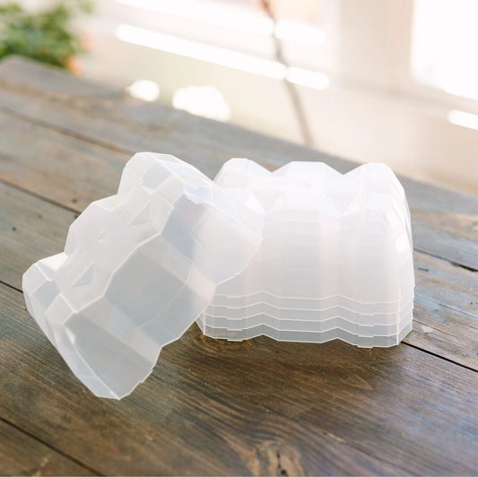Clear plastic seed domes on a wooden surface