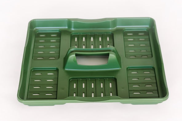 Green plastic tray for seed cells with slots for drainage and a carrying handle